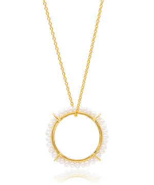 Gold necklace with a circular pendant featuring small pearls on a white background