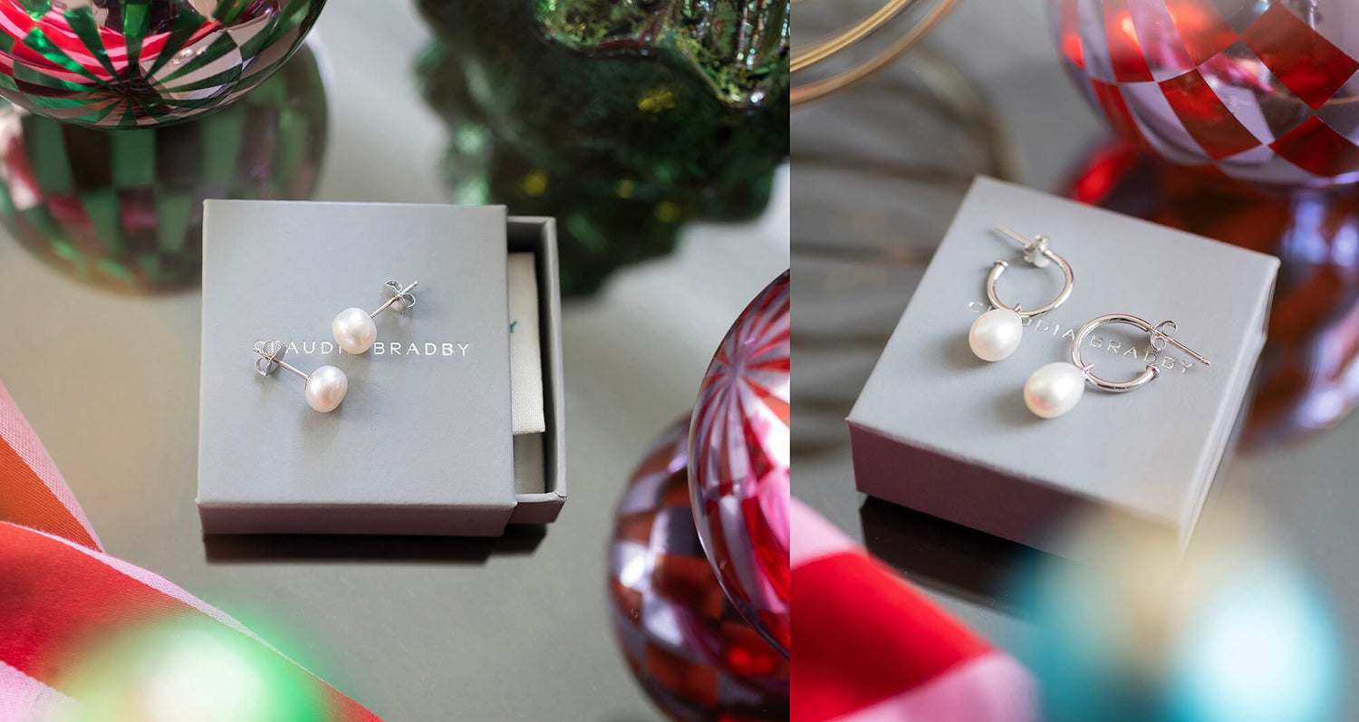 Pearl earrings in a box with a decorative background